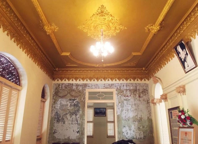 Kèo của ngôi nhà đều làm bằng gỗ quý, tường dày 20cm, nền lát gạch bông, 8 mái lợp ngói vảy cá. Trên vòm cửa được chạm các hình ảnh rồng, phượng, hoa... rất tinh xảo. Trên vách tường ở tiền sảnh có 4 bức tranh tường nhưng hiện nay đã bị mờ, mất hết chi tiết và màu sắc. Ảnh: mytho.tiengiangtourist.vn.
