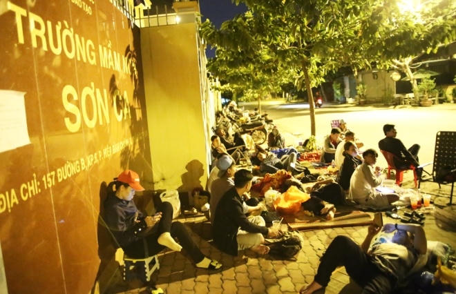 Phụ huynh nằm la liệt trước cổng trường để mong con có một suất học tại trường Sơn Ca. (Ảnh: VnExpress)