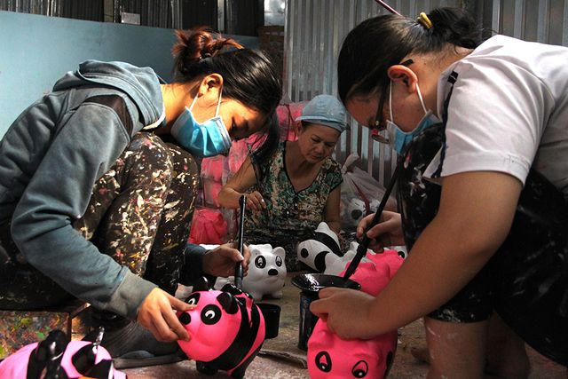 Thợ thủ c&ocirc;ng trang tr&iacute; heo đất ngộ nghĩnh trước khi đưa ra thị trường.