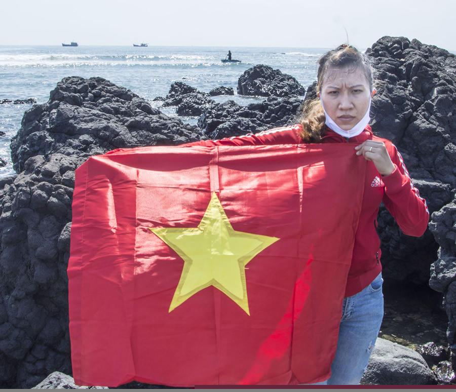 Chị Chi mang theo cờ Tổ quốc, ra mũi đất Ba Làng An, nơi gần Hoàng Sa nhất kể từ đất liền để ngóng trông con tàu trở về.