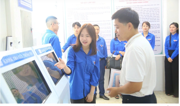 Thanh niên tình nguyện hướng dẫn người dân đăng ký thủ tục hành chính. (Ảnh: Ngọc Anh)