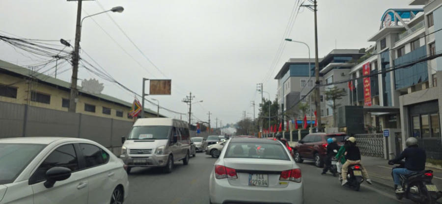 Phương tiện và người tấp nập trước đoạn rẽ vào đền.
