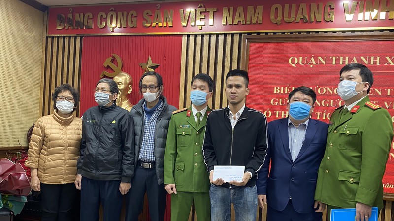 Ông bà và bố cháu bé cảm ơn và tặng quà cho anh Mạnh.  