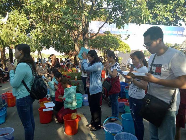 Người d&acirc;n khấn niệm trước khi ph&oacute;ng sinh chim, c&aacute;. Ảnh chụp tại ch&ugrave;a Diệu Ph&aacute;p, TP.HCM chiều 19-2. Ảnh: TR&Uacute;C PHƯƠNG