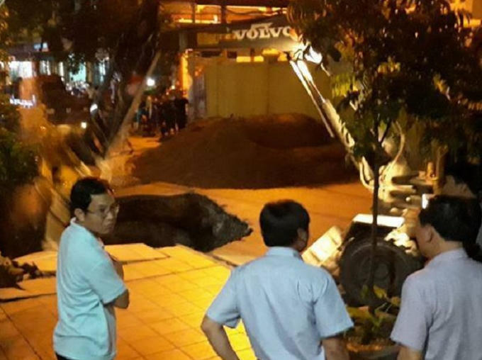 Lực lượng chức năng địa phương có mặt tiến hành san lấp hố "tử thần" đảm bảo an toàn cho người dân.