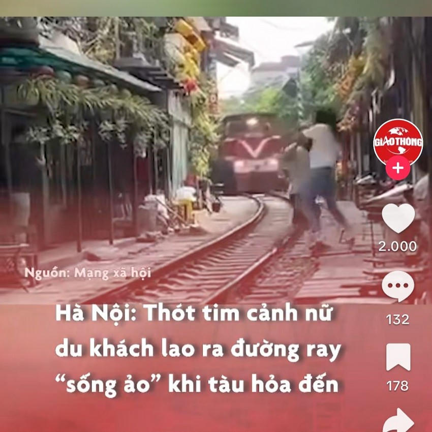 Hình ảnh một người phụ nữ chạy ra đường ray nhảy múa trước một đoàn tàu hoả. (Ảnh: Châu Anh chụp lại từ màn hình)