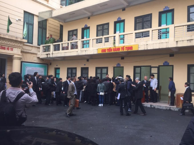 Các Luật sư trao đổi sau phiên nghỉ trưa.              Các bị cáo được che ô đưa vào phòng nghỉ.