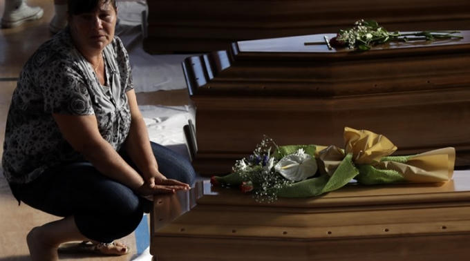 Người thân của các nạn nhân trong trận động đất đặt hoa tưởng niệm. (Ảnh: AP)