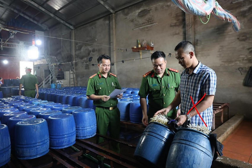Đối tượng Nguyễn Văn Tân (áo kẻ) - chủ cơ sở sản xuất 60 tấn giá đỗ ngậm hóa chất. Ảnh: Công an Bắc Giang.