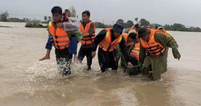Lực lượng chức năng cứu giúp người dân vùng lũ.