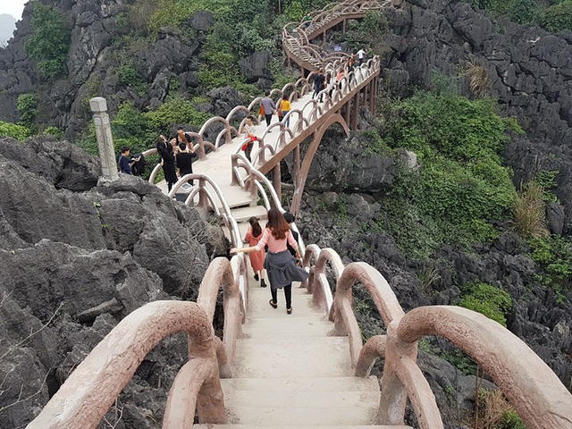 Công ty CP du lịch Tràng An đã tự ý khoan đá chôn cột bê tông, lắp đặt bậc thang, hành lang lan can tạo đường lên xuống núi Cái Hạ. Toàn bộ công trình "khủng" này chưa được cấp phép, vi phạm nghiêm trọng quy định của pháp luật. (ảnh: Dantri.com.vn).