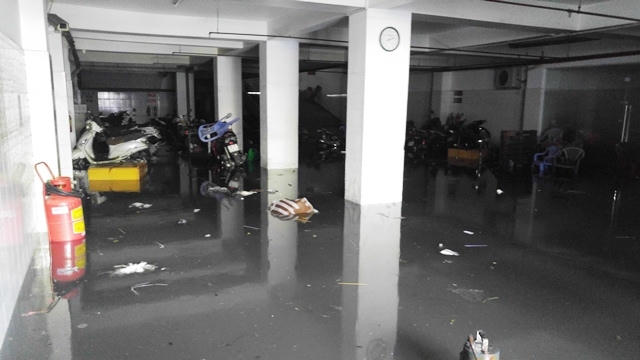 Tại chi nhánh một ngân hàng nằm trên đường Phan Xích Long, 8h30 sáng 27/8 (hơn 12 giờ sau khi xảy ra mưa lớn) tầng hầm của tòa nhà này vẫn ngập sâu hơn nửa bánh xe máy.