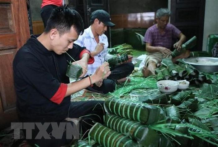Gói bánh chưng, bánh tét tại một hộ gia đình ở làng Chuồn, Thừa Thiên-Huế. (Ảnh: Hồ Cầu/TTXVN)