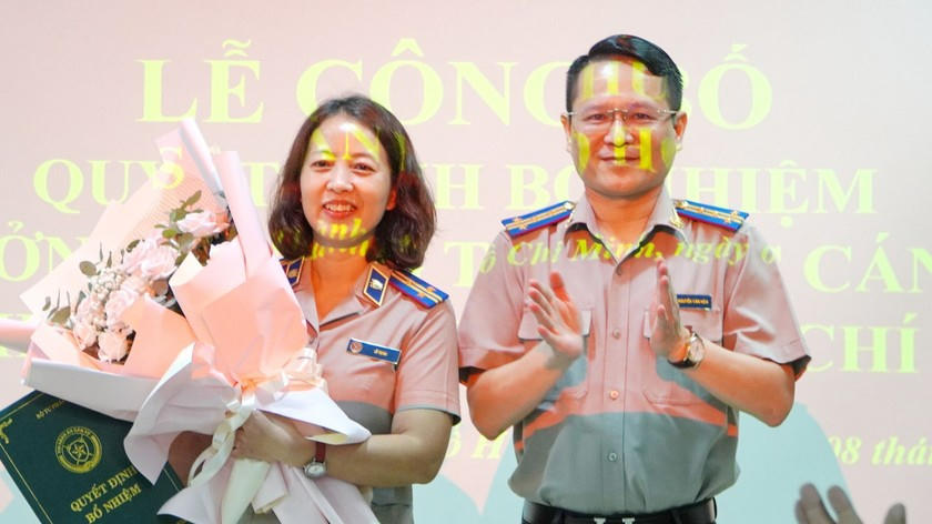 Đồng chí Nguyễn Văn Hòa - Bí thư Đảng ủy, Cục trưởng Cục THADS TPHCM trao Quyết định, tặng hoa chúc mừng đồng chí Lê Thị Mai. (Ảnh: Cẩm Tú)
