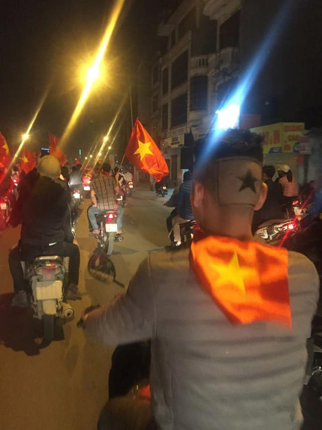 Cạo trắng sau gáy để lại khoảng tóc hình ngôi sao. Mái tóc nổi bật giữa dòng người đi cổ vũ U23 Việt Nam đêm 23/1 (Ảnh: Facebook)