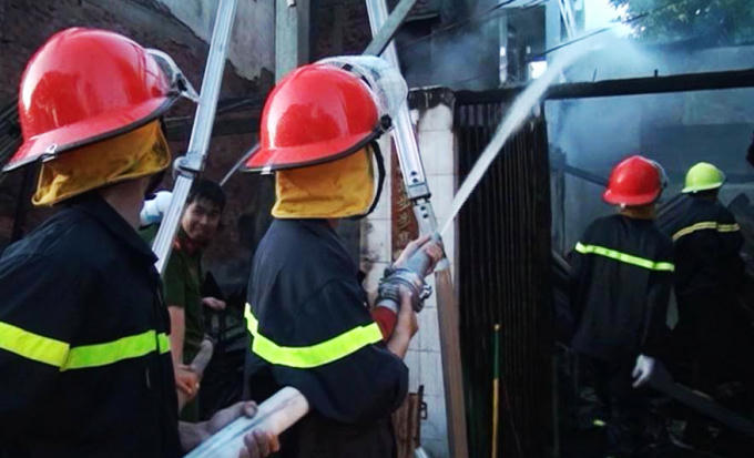 Lực lượng chữa cháy chuyên nghiệp đang phun nước dặp tắt đám cháy một ngôi nhà