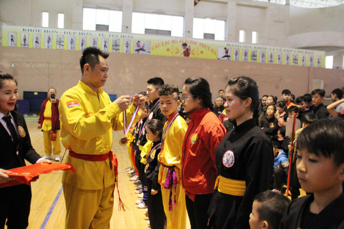 Võ sư Đặng Tam Thuận, Chưởng môn sáng lập Trung tâm Đào tạo Võ Thuật tài năng trẻ Việt Nam trao tặng huy chương cho các võ sĩ.