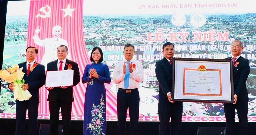 Phó bí thư thường trực Tỉnh ủy Hồ Thanh Sơn và Phó chủ tịch UBND tỉnh Nguyễn Thị Hoàng trao bằng công nhận và tặng hoa cho lãnh đạo huyện Định Quán nhân lễ đón nhận bằng công nhận huyện Định Quán đạt chuẩn huyện nông thôn mới nâng cao năm 2023. Ảnh: BĐN