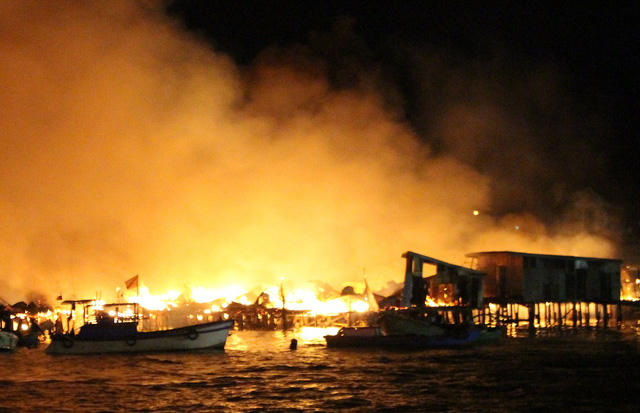 22h30 ng&agrave;y 17/1, h&agrave;ng chục căn nh&agrave; gỗ tạm bợ ở cửa s&ocirc;ng C&aacute;i (thuộc phường Vĩnh Phước, TP Nha Trang, Kh&aacute;nh H&ograve;a) bất ngờ bốc ch&aacute;y dữ dội, cột kh&oacute;i cao h&agrave;ng chục m&eacute;t