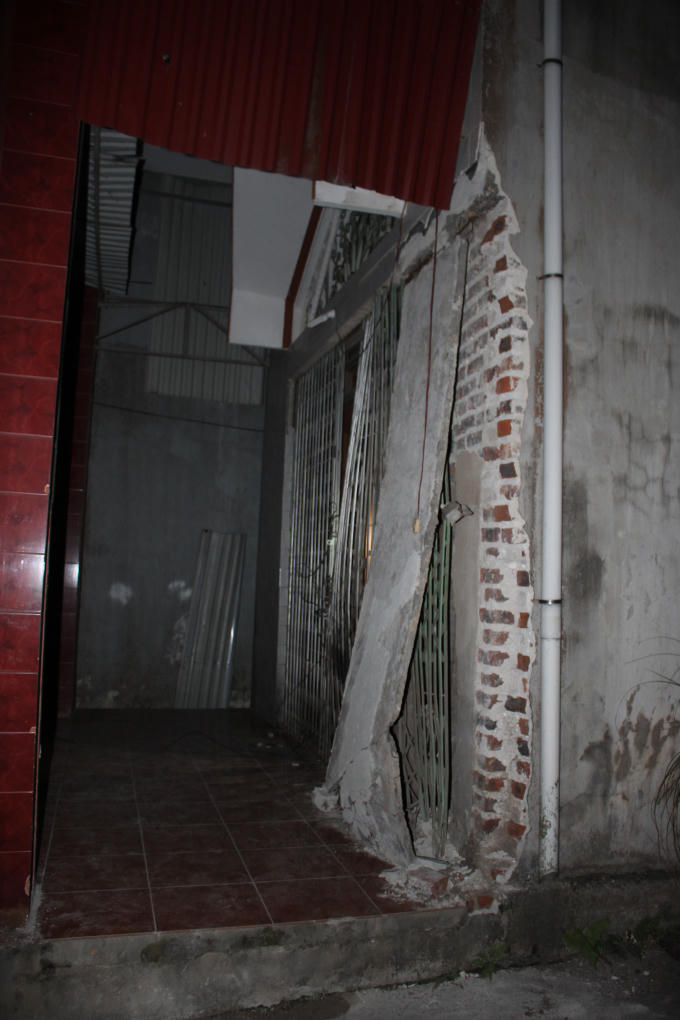 Vụ nổ khiến toàn bộ phần tường phía trước và cửa xếp tầng một của gia đình nhà ông Tính bị hư hỏng nặng.