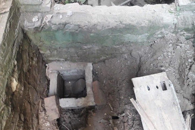 Hố gạch được ph&aacute;t hiện tại vị tr&iacute; gi&aacute;p ranh giữa nh&agrave; l&agrave;m việc của Ban quản l&yacute; Dự &aacute;n v&agrave; tường r&agrave;o nh&agrave; l&agrave;m việc của Viện kiểm s&aacute;t nh&acirc;n d&acirc;n huyện Ph&uacute; Xuy&ecirc;n. Ảnh Ngọc Linh.