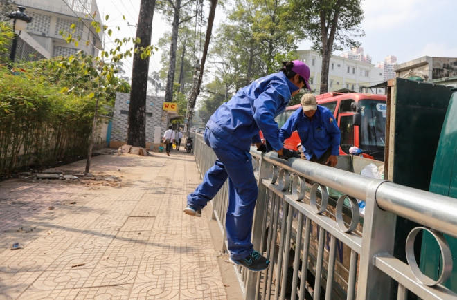 Còn anh Lâm (nhân viên vệ sinh) mỗi lần đi lấy rác phải trèo ra hàng rào cao khoảng 1,5 m. "Tôi toàn phải nhảy từ trên xe vào trong vỉa hè gom rác", anh Lâm chia sẻ.