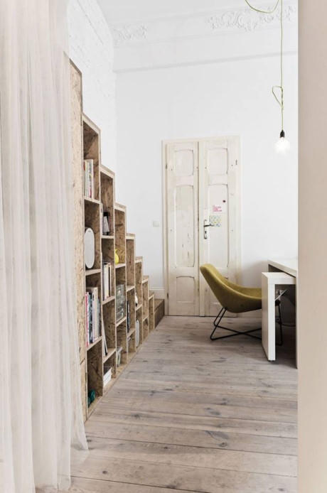 Phía sau ghế sofa là góc làm việc nhỏ với chiếc bàn trắng và chiếc đèn bàn cùng tông màu. Toàn bộ sàn nhà đều được ốp gỗ tạo nên một không gian vô cùng ấm cúng và sang trọng.