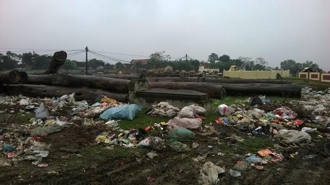 Một ngôi mộ bị bao vây bởi rác (ảnh Duy Ngợi).