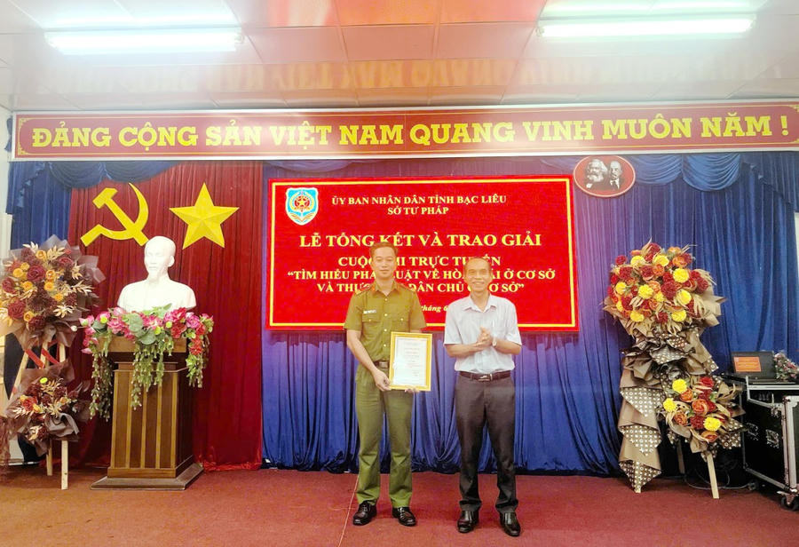 Ông Trần Minh Đức - Phó Giám đốc Sở Tư pháp Bạc Liêu, Phó Trưởng Ban Tổ chức Cuộc thi, trao giải Nhì tập thể cho Trường THPT Lê Thị Riêng và giải Nhì cá nhân cho anh Vưu Chí Cường (Công an tỉnh Bạc Liêu).