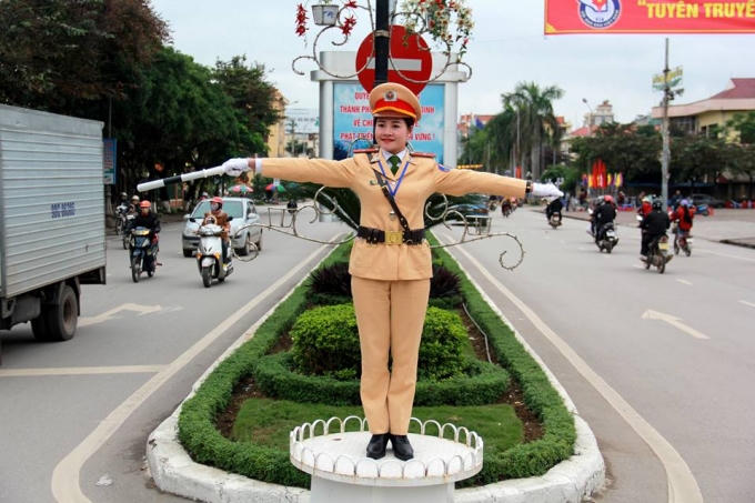 Nữ CSGT xinh đẹp đứng dưới cái nắng và khói bụi làm nhiệm vụ