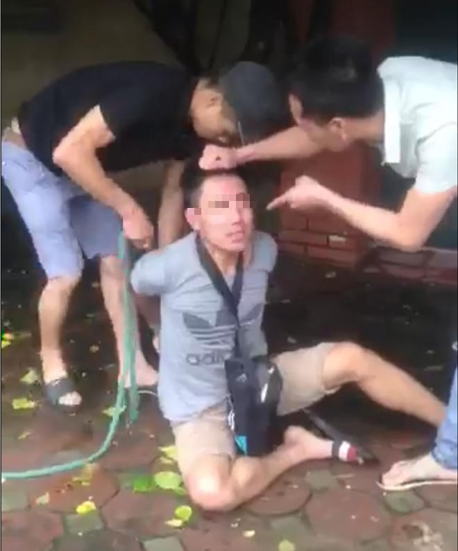 Người áo trắng túm tóc cáo buộc nam thanh niên trộm xe máy (ảnh cắt từ clip).