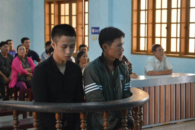 Bị cáo Vũ (bên trái màn hình) và Ngà đứng trước vành móng ngựa.