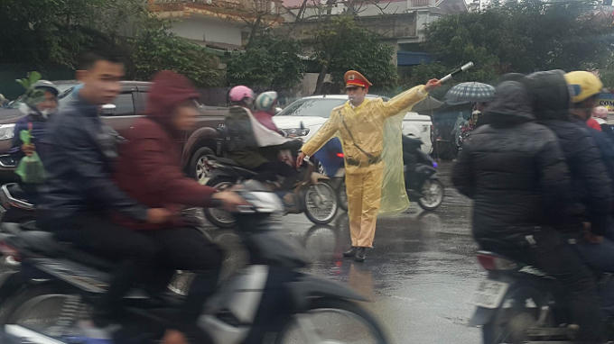 Lực lượng CSGT gồng mình đội mưa phân luồng giao thông tại các tuyến đường giao cắt gây ùn tắc.