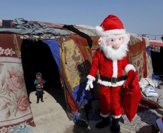Ông già Noel tặng quà cho những đứa trẻ nghèo ở khu dân cư nghèo tại Najaf, phía nam thủ đô Baghdad. (Ảnh: Reuters)