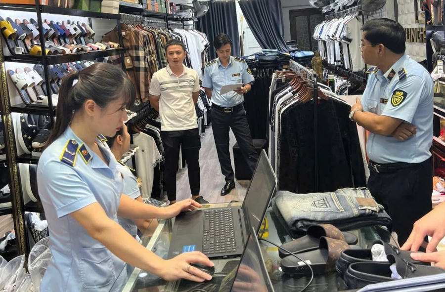 Lực lượng QLTT TP Hải Phòng tiến hành kiểm tra phát hiện nhiều sản phẩm thời trang giả mạo nhãn mác các thương hiệu tên tuổi quốc tế. Ảnh: Cục QLTT TP Hải Phòng