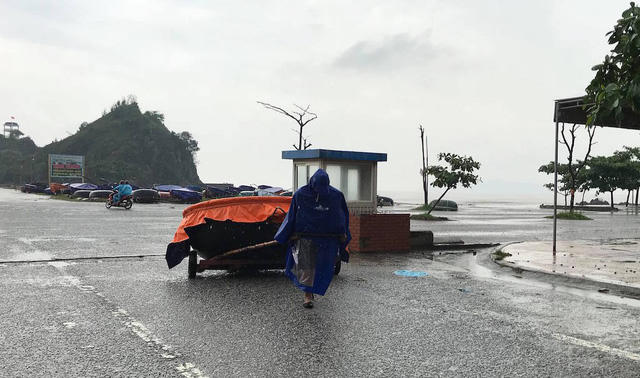 Một ngư dân kéo thuyền vào bờ.