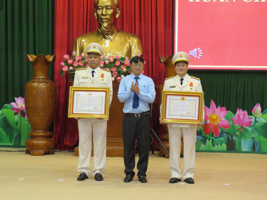 Đại tá Trần Anh Sơn –Phó Giám đốc Công an tỉnh (bên phải) và Thiếu tá Nguyễn Thành Hưng – Phó Trưởng phòng PC02, Công an TP.HCM (bên trái) nhận Huân chương chiến công hạng nhì