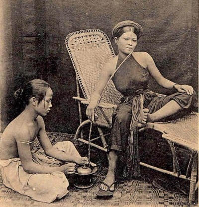 Một phụ nữ con nhà quyền quý đang hút thuốc bên người hầu.