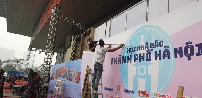 Công nhân đang hoàn thiện biển, bảng quảng cáo.