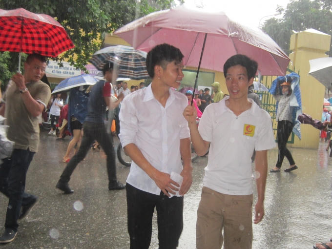 Dù vội vã ra về, nhưng nhiều bạn vẫn tranh thủ "kể" về bài thi Vật Lý chiều nay với người nhà. Ảnh: Cao Oanh