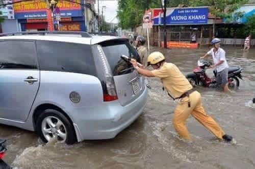 Gồng mình đẩy xe ra khỏi khu vực ngập lụt.(Nguồn: Facebook).