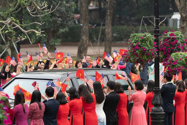 Cờ Việt Nam v&agrave; cờ Mỹ tung bay đ&oacute;n đo&agrave;n xe của Tổng thống Trump.