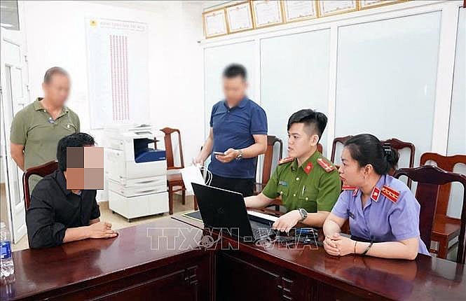 Cơ quan chức năng làm việc với đối tượng Phan Văn Phú. Ảnh: TTXVN