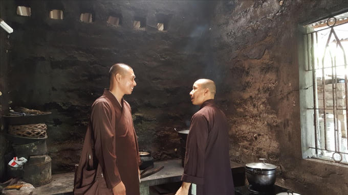 Hai vị tu h&agrave;nh b&agrave;n luận đạo ph&aacute;p trong vui vẻ ngay trong bếp.