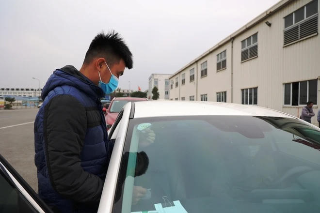 Dán tem đăng kiểm cho phương tiện đã đạt kiểm định tại một trung tâm đăng kiểm xe cơ giới. (Ảnh: Minh Hiếu/Vietnam)
