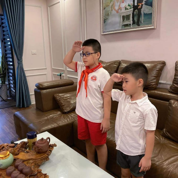 Hai học sinh Trường Tiểu học Dịch Vọng A đứng trang nghiêm thực hiện nghi lễ chào cờ khai giảng năm học mới.