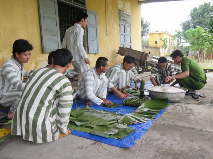 Cán bộ cùng phạm nhân gói bánh tét (ảnh: Phương Nam).