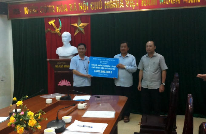 Đại diện tỉnh Thanh H&oacute;a v&agrave; Ng&acirc;n&nbsp;h&agrave;ng Thương mại Cổ phần Ngoại thương Việt Nam trao hỗ trợ cho huyện Mường L&aacute;t để khắc phục thiệt hại sau lũ.