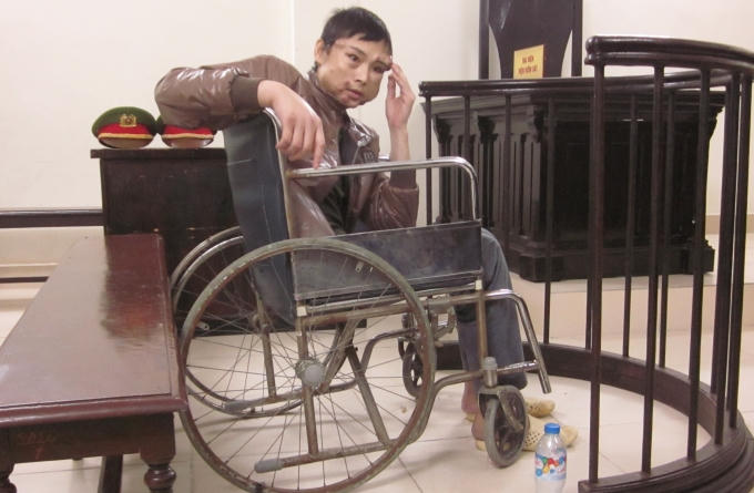 Bị cáo Tân trên chiếc xe lăn ngồi co rúm trước vành móng ngựa.