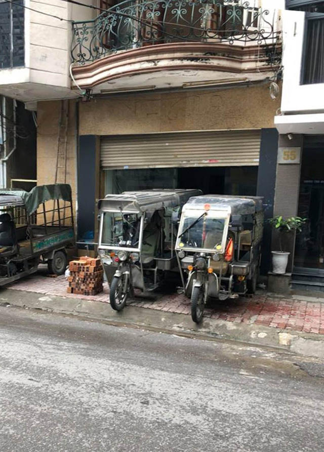 Nhóm người điều khiển xe ba bánh đỗ trước cửa nhà bà Nhung để cản trở, không cho bà Nhung vào nhà.